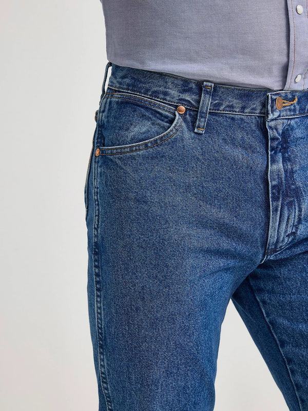 Men's Wrangler Cowboy Cut Original Fit jeans in stonewashed denim, shown on a model with a casual pose.
