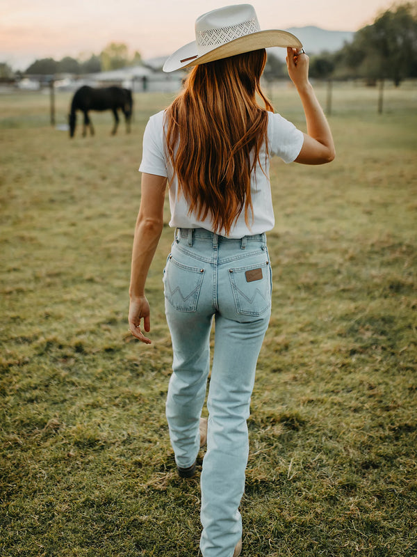 KONTOOR Wrangler women's cowboy cut slim fit bleach jeans showing distressed denim and classic five-pocket design